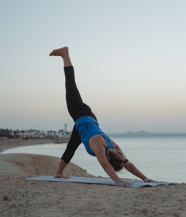 Woman in a calm yoga pose on a cream background.